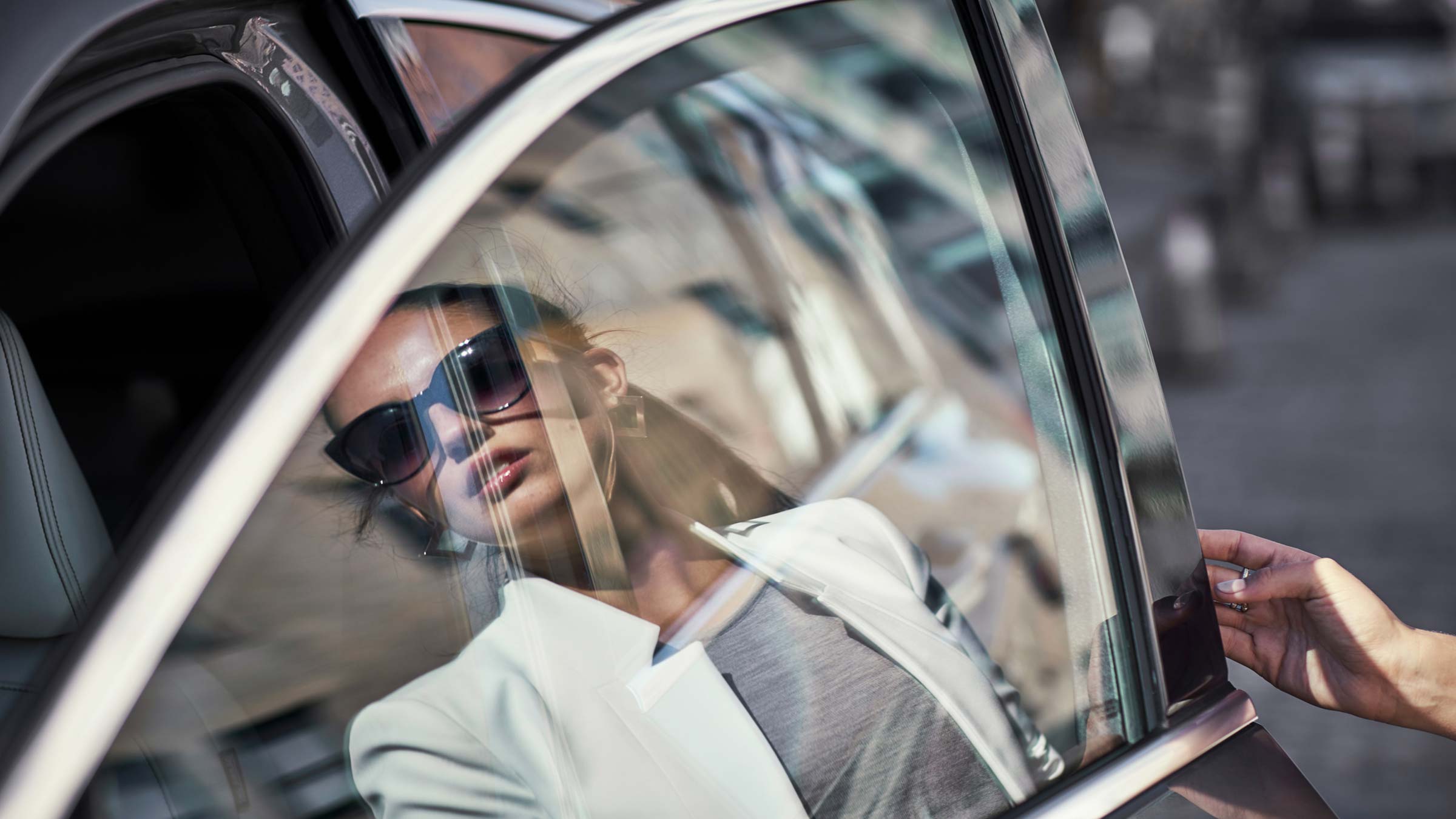 A reflection of a woman through the 2022 INFINITI QX50 SUV window.